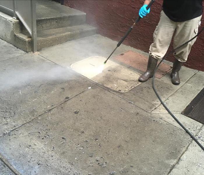 SERVPRO tech pressure washing the walkway of a Folcroft, PA home
