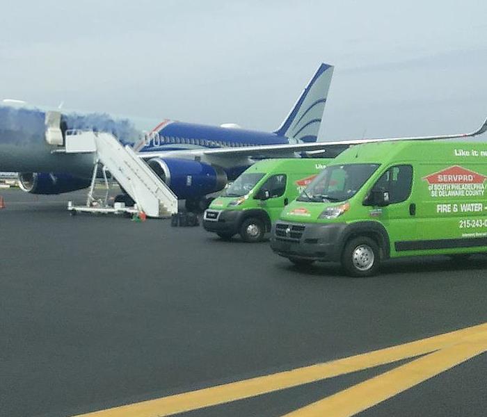 a servpro van parked next to an airplane