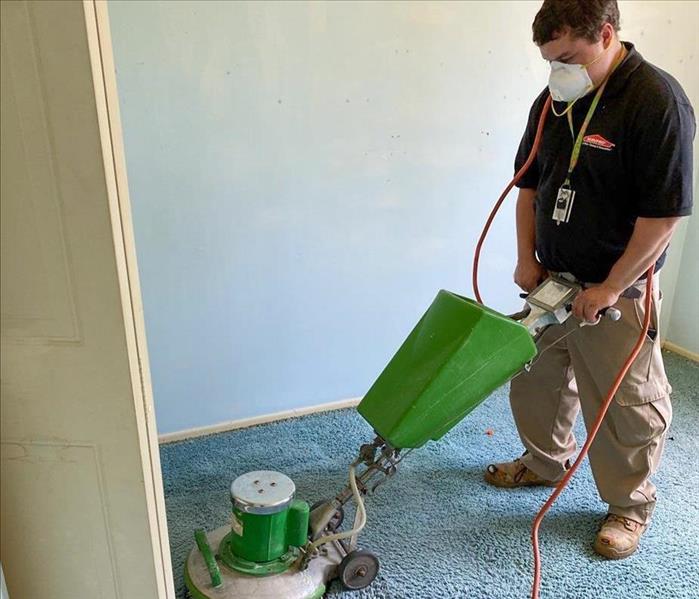 servpro employee using equipment to clean carpet