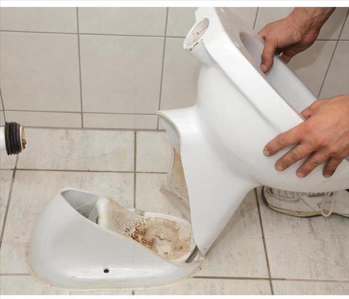  Plumber replacing broken toilet in a washroom