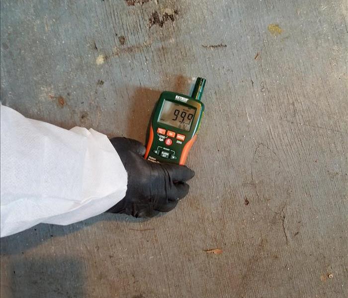 SERVPRO technician checking for mold on the floor of a Collingdale building