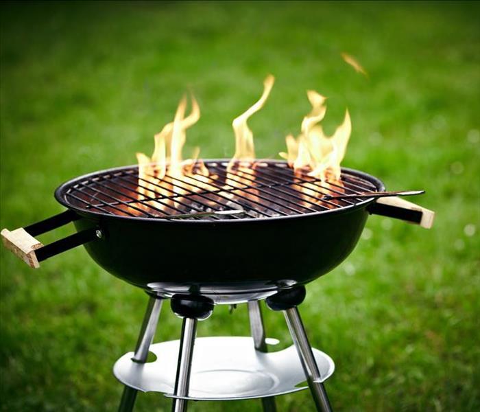 Flames rising from a grill. 