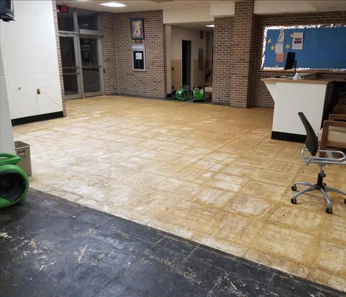 Front lobby with drying equipment and removed floor panels due to damage